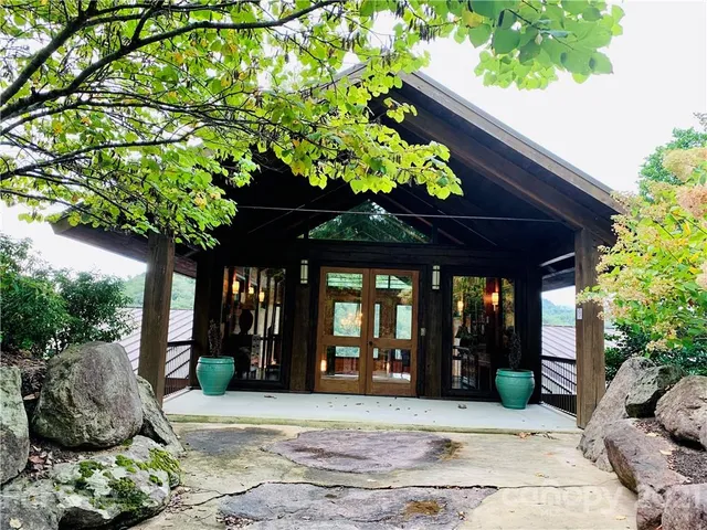 a dining hall with stainless steel appliances kitchen island granite countertop a table chairs and a refrigerator