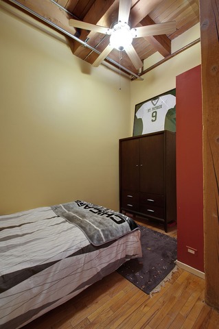 525 North Ada Street, Unit 27 Chicago, IL 60642 - Photo 14 of 18 a bedroom with a bed and a flat screen tv