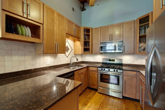 525 North Ada Street, Unit 27 Chicago, IL 60642 - Photo 9 of 18 a kitchen with stainless steel appliances granite countertop a stove a sink and a microwave