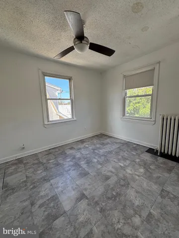 an empty room with a ceiling fan and window