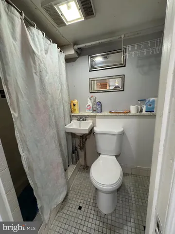 a bathroom with a sink a toilet a mirror and shower