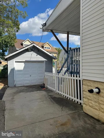 a view of a backyard with plants and large tree