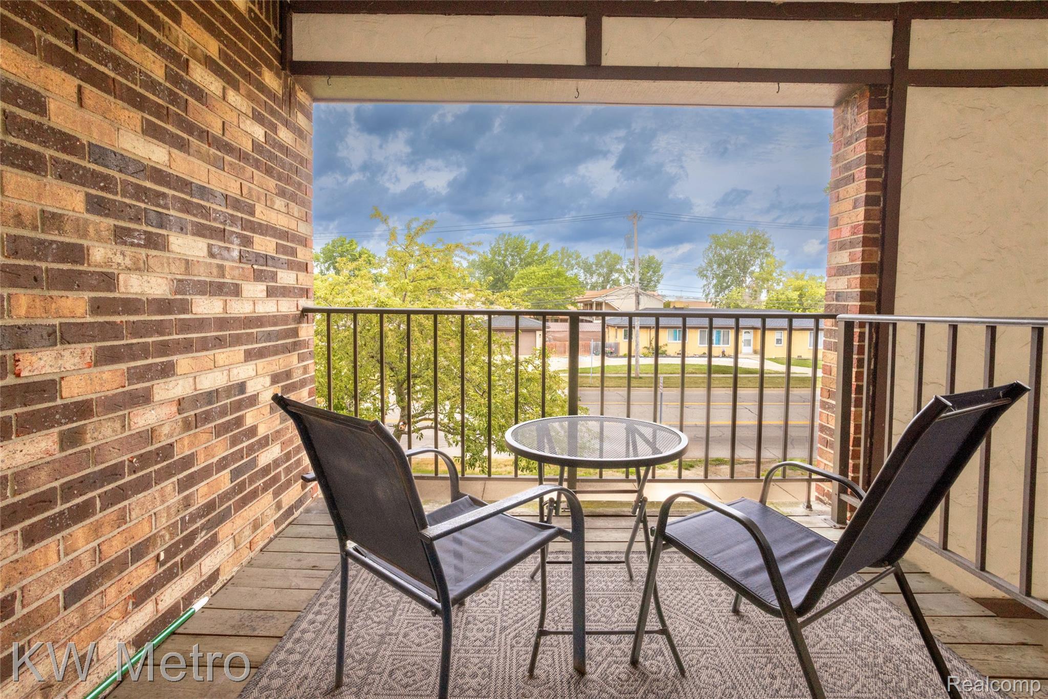 29948 Utica Road Roseville, MI 48066 - Photo 11 of 12 Private balcony featuring a brick exterior wall, metal railing, and a wood-finish floor
