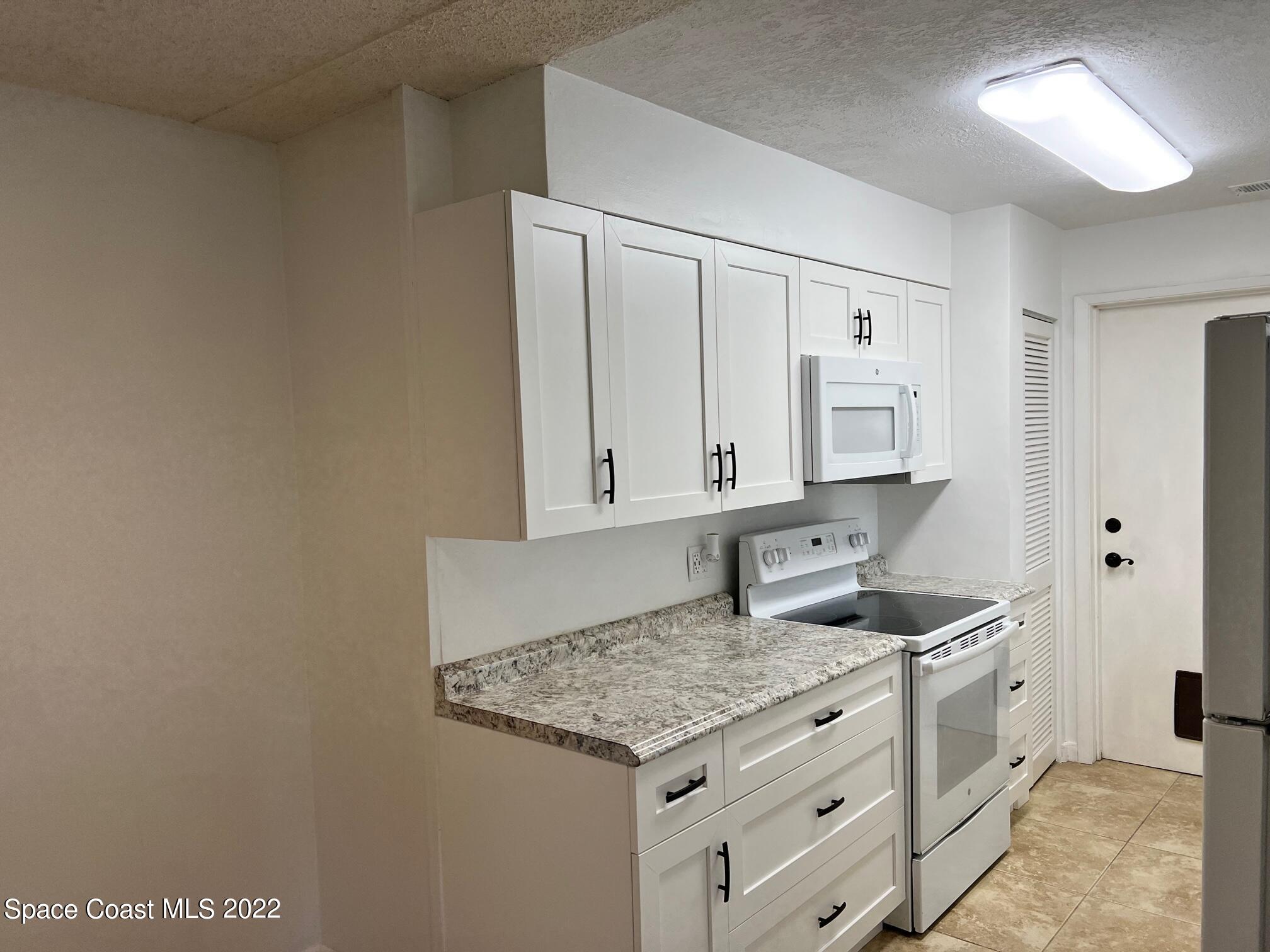 222 Brian Drive Indialantic, FL 32903 - Photo 6 of 14 a kitchen with granite countertop a sink and cabinets