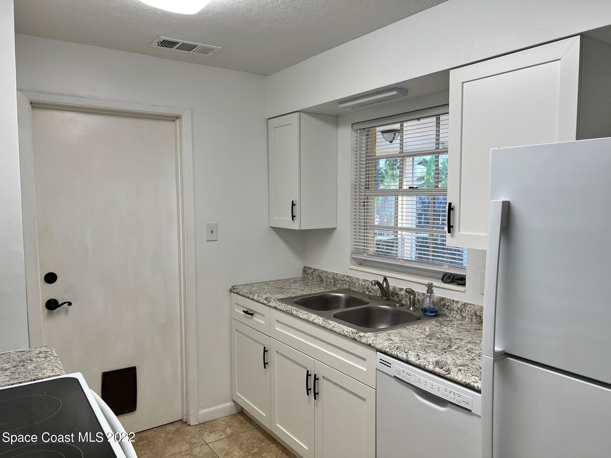 222 Brian Drive Indialantic, FL 32903 - Photo 7 of 14 a kitchen with stainless steel appliances granite countertop a sink stove and refrigerator