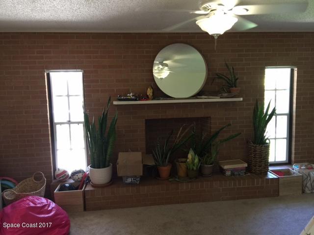222 Brian Drive Indialantic, FL 32903 - Photo 9 of 14 a living room with a fireplace and a large window