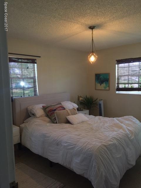 222 Brian Drive Indialantic, FL 32903 - Photo 10 of 14 a bedroom with a bed and a lamp