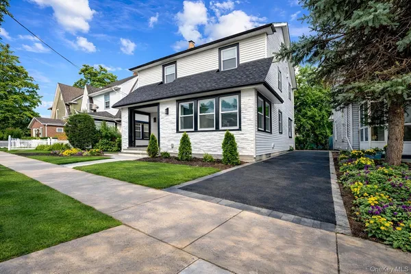 a front view of a house with a garden and plants