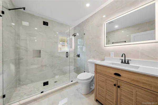 a bathroom with a sink a toilet and shower