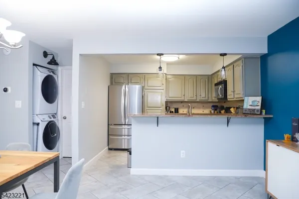 a kitchen with a refrigerator a microwave a sink and cabinets