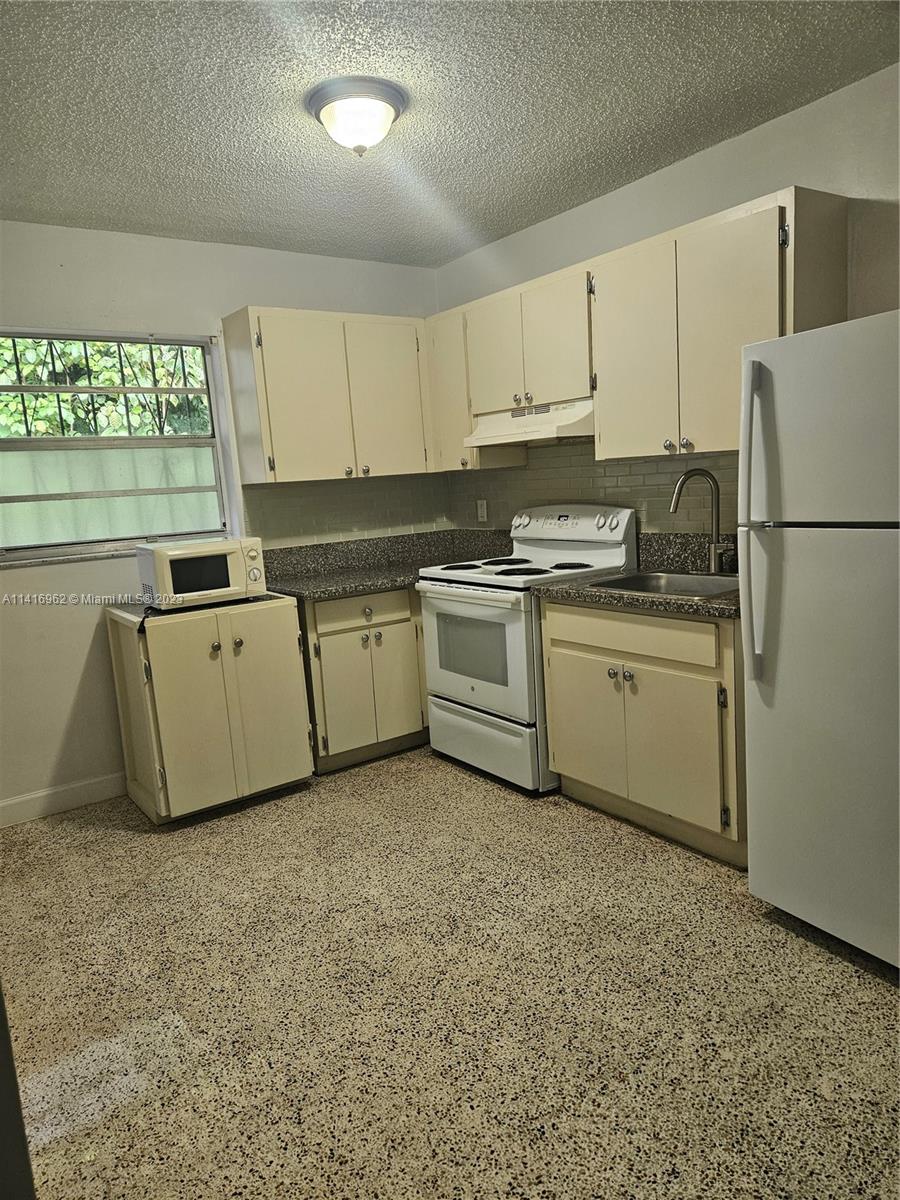 Allapattah Miami, FL 33125 - Photo 10 of 10 a kitchen with a sink a stove a refrigerator and cabinets