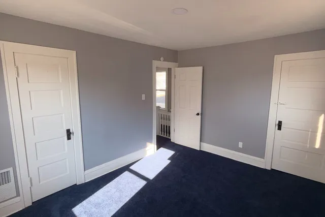 an empty room with closet and wooden floor