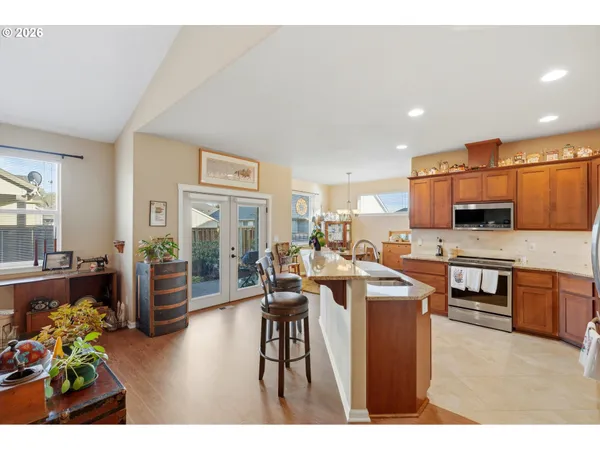 a living room with stainless steel appliances lots of furniture and a view of kitchen