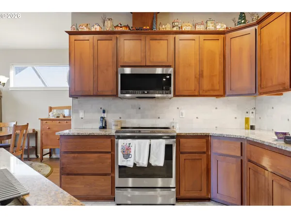 a kitchen with stainless steel appliances granite countertop a stove a sink and a microwave