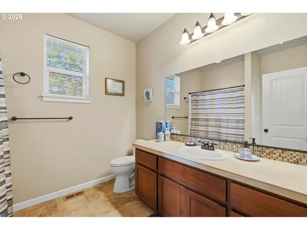 a bathroom with a sink a toilet a mirror and vanity