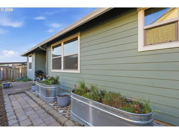 a front view of a house with a yard and potted plants