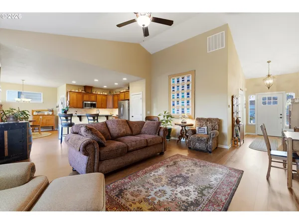 a living room with furniture kitchen view and a chandelier