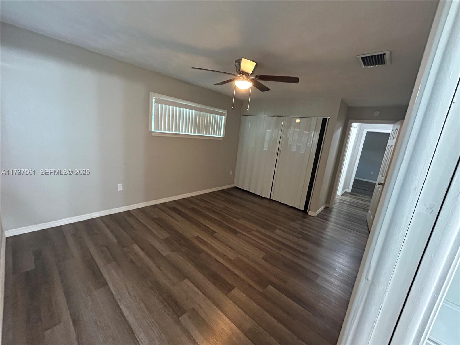 7403 Foxbloom Drive Port Richey, FL 34668 - Photo 9 of 45 an empty room with wooden floor and windows