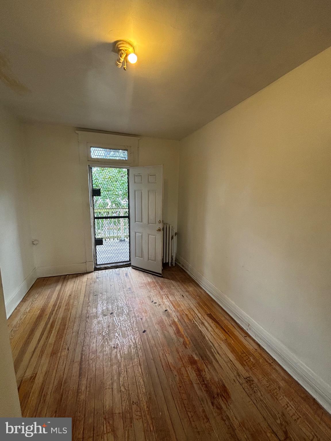 2417 North Pulaski Street Baltimore, MD 21217 - Photo 13 of 26 an empty room with wooden floor and windows