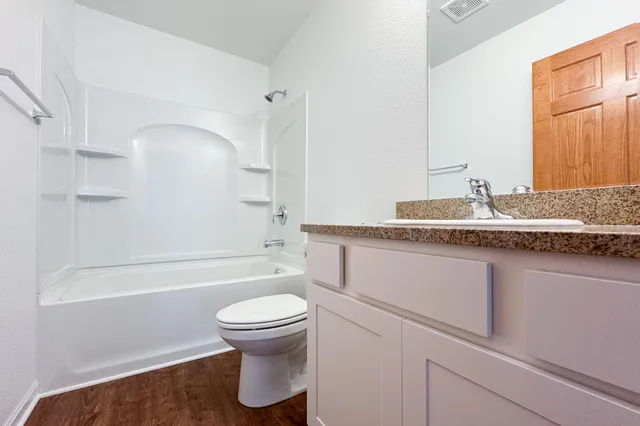 a bathroom with a granite countertop sink toilet and shower