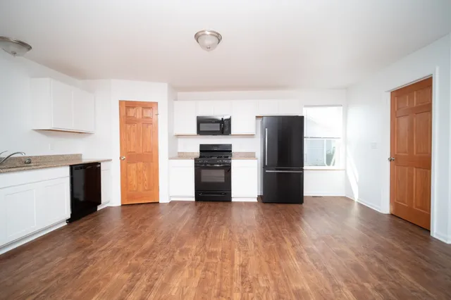 a kitchen with a refrigerator and a stove top oven