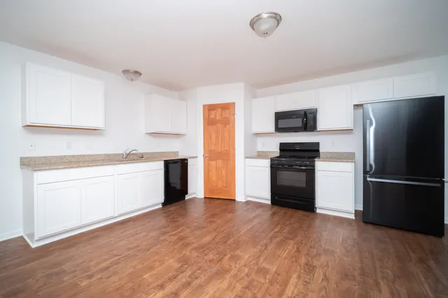 a kitchen with a refrigerator stove and white cabinets