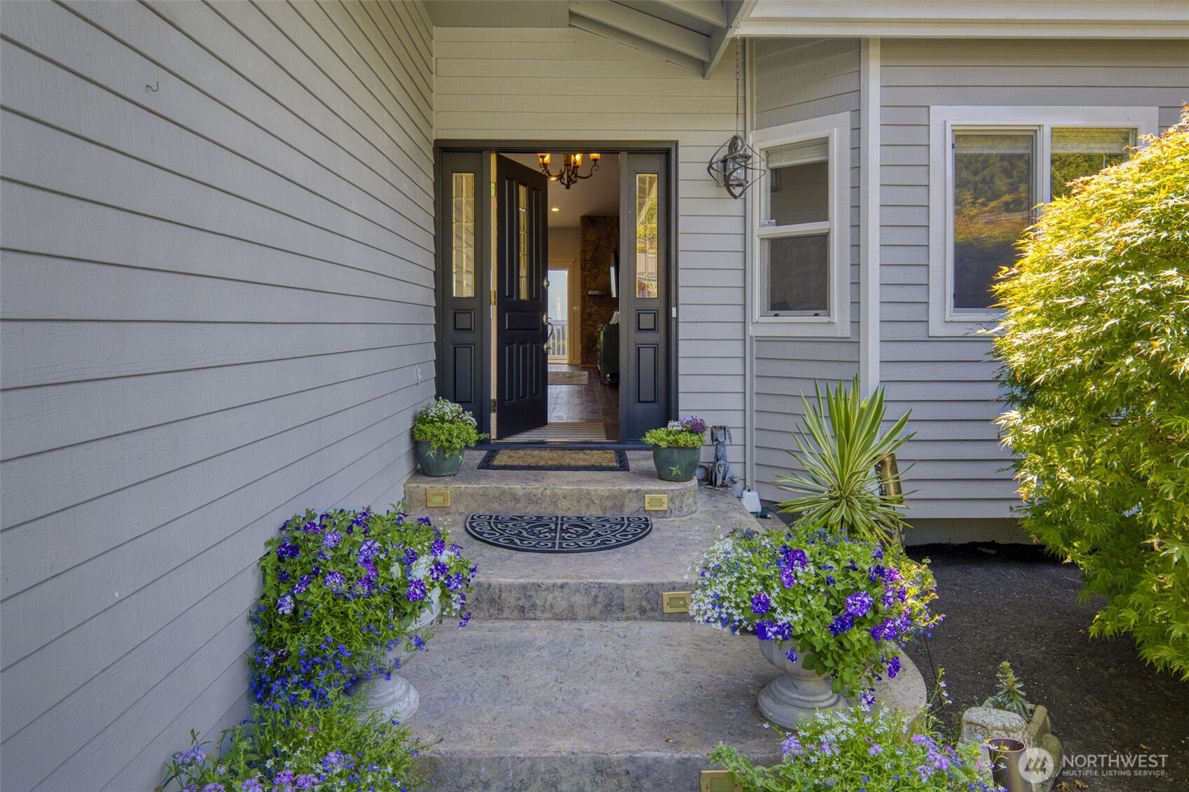 38291 Doe Road Northeast Hansville, WA 98340 - Photo 12 of 40 a front view of a house with a flower garden