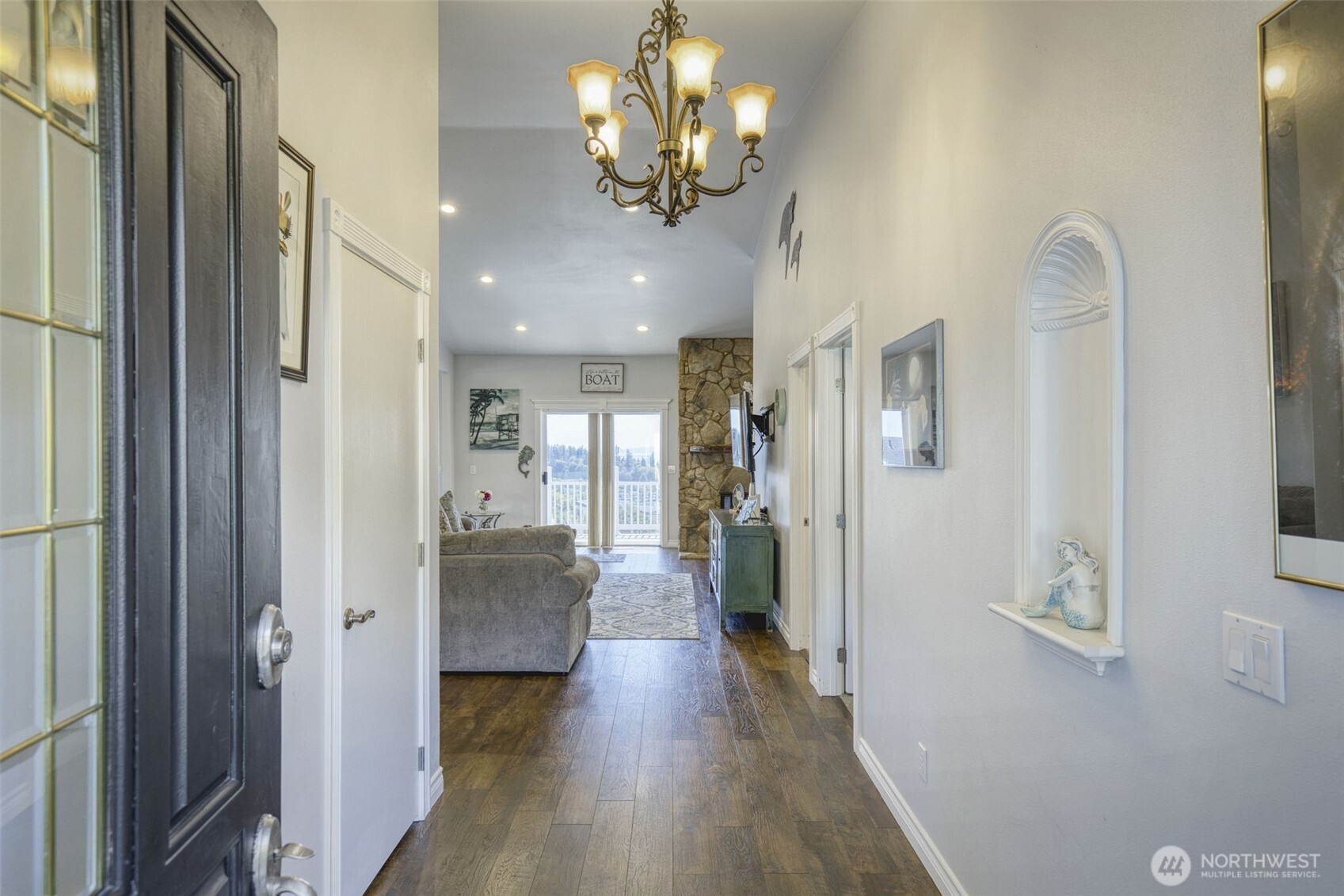 38291 Doe Road Northeast Hansville, WA 98340 - Photo 13 of 40 a view of a hallway with wooden floor and a chandelier