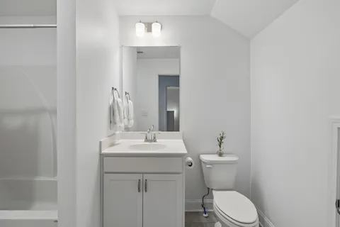 a bathroom with a toilet sink and mirror
