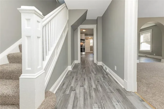a view of a hallway with wooden floor and staircase