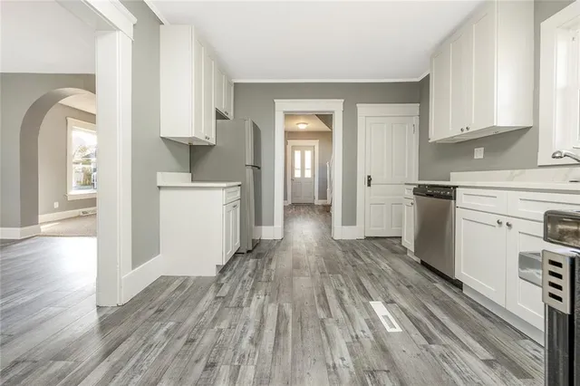 a kitchen with wooden floors and white appliances