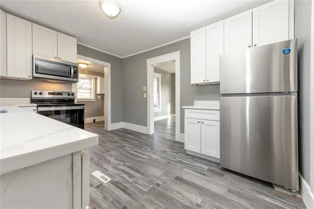 a kitchen with a refrigerator a stove top oven a cabinetry and kitchen island