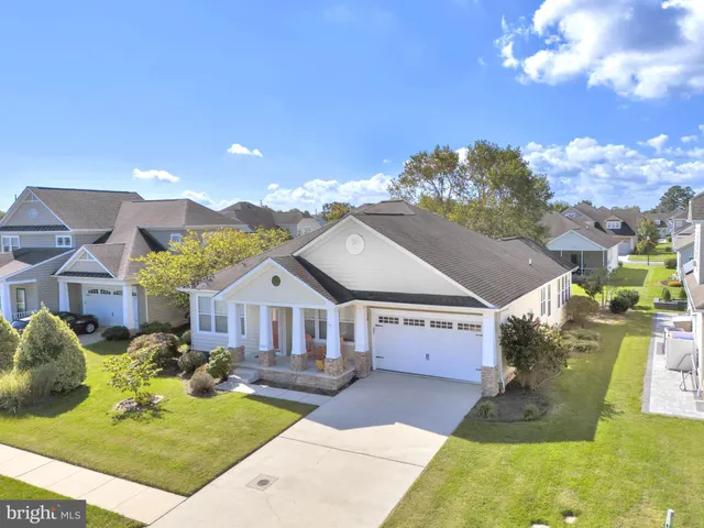 a front view of a house with a yard and potted plants