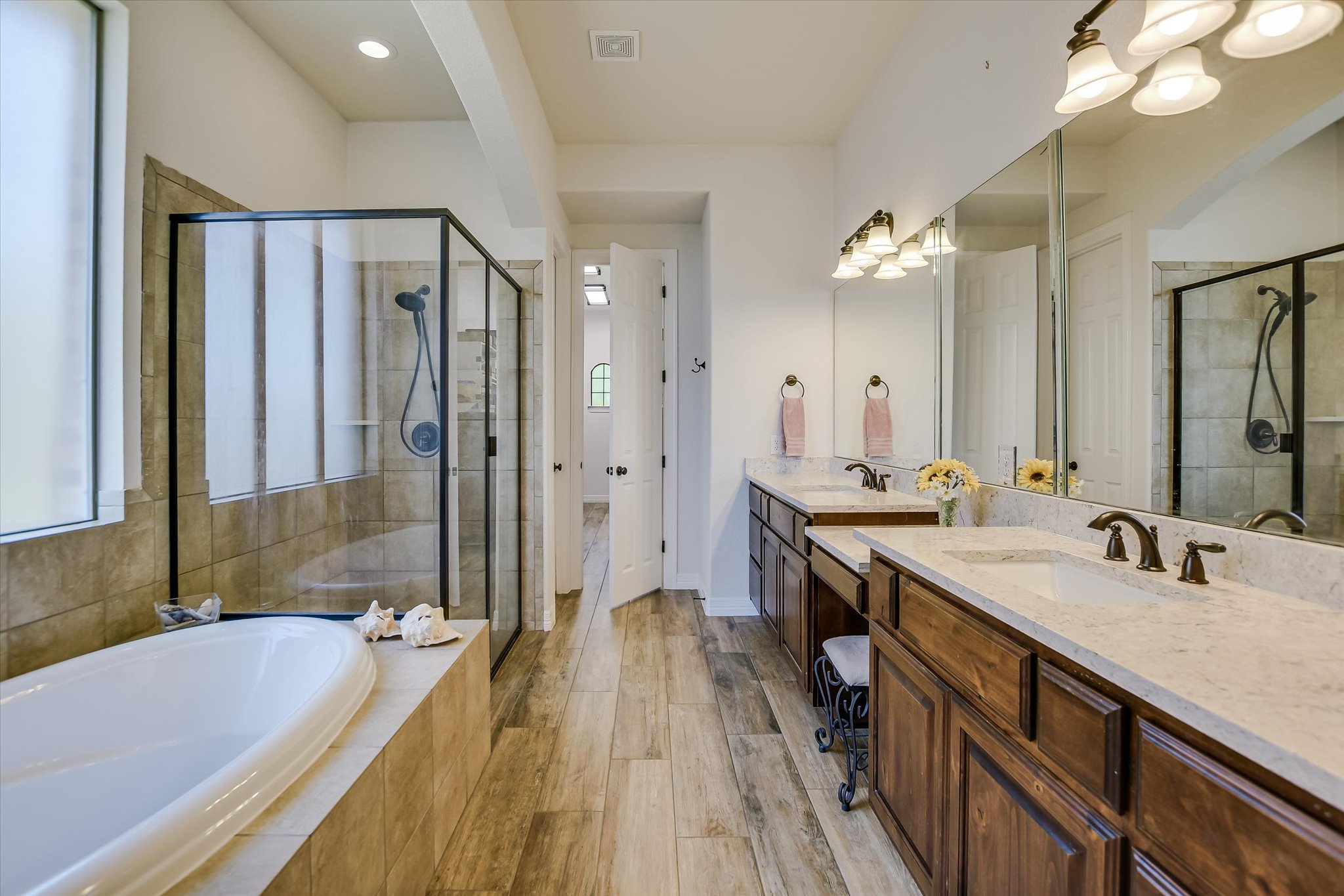 2404 First View Leander, TX 78641 - Photo 17 of 38 a spacious bathroom with a granite countertop tub double vanity sink a mirror and a shower