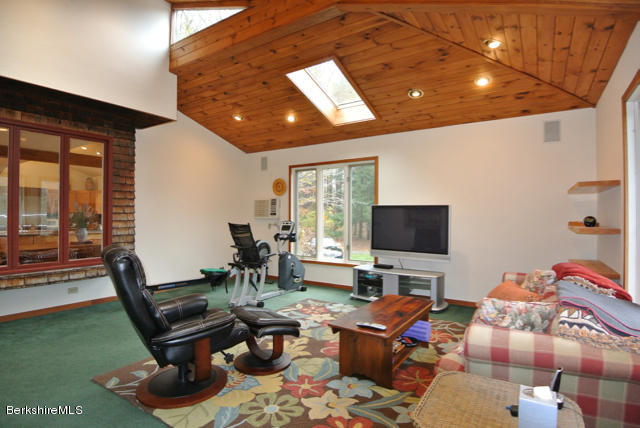 16 Averic Road Stockbridge, MA 01266 - Photo 10 of 24 a living room with furniture a flat screen tv and a floor to ceiling window