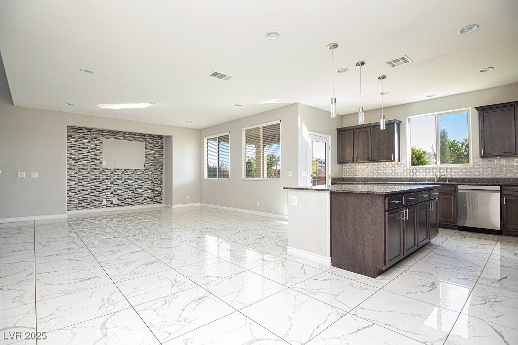 6856 Pivot Point Street Las Vegas, NV 89148 - Photo 12 of 32 Kitchen featuring light marble finish flooring, decorative backsplash, dark brown cabinetry, pendant lighting, and recessed lighting