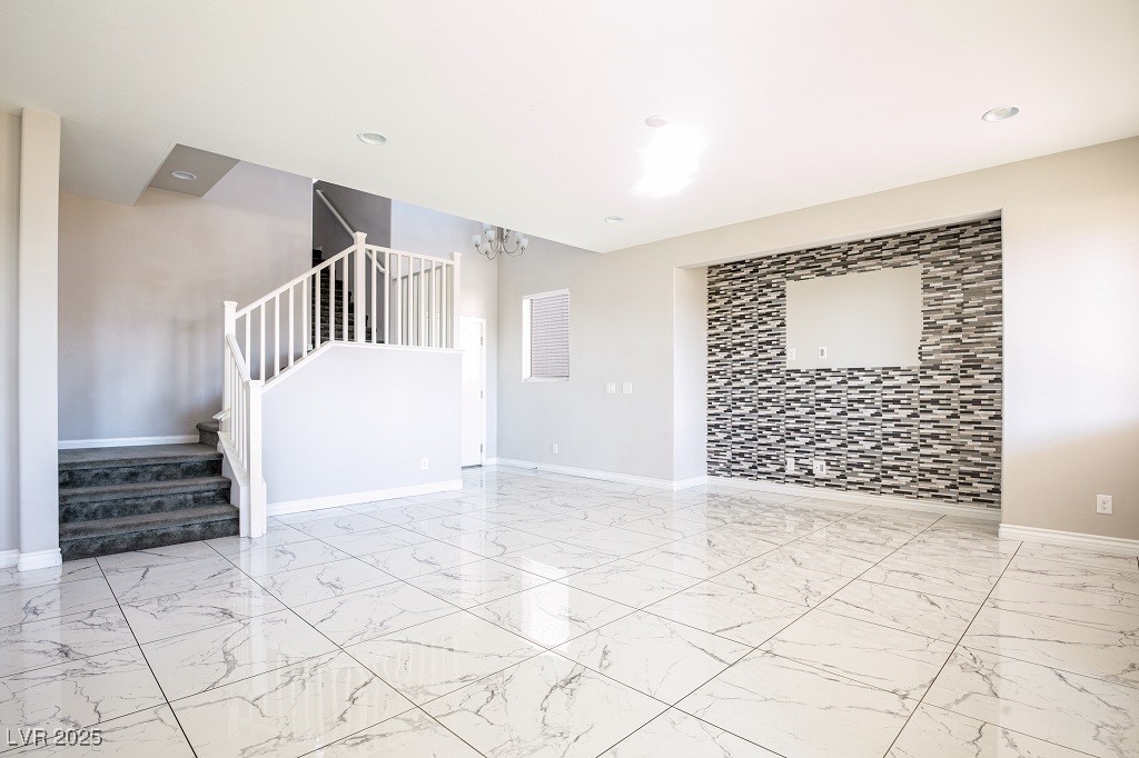 6856 Pivot Point Street Las Vegas, NV 89148 - Photo 13 of 32 Unfurnished room with stairs, light marble finish flooring, a chandelier, and recessed lighting