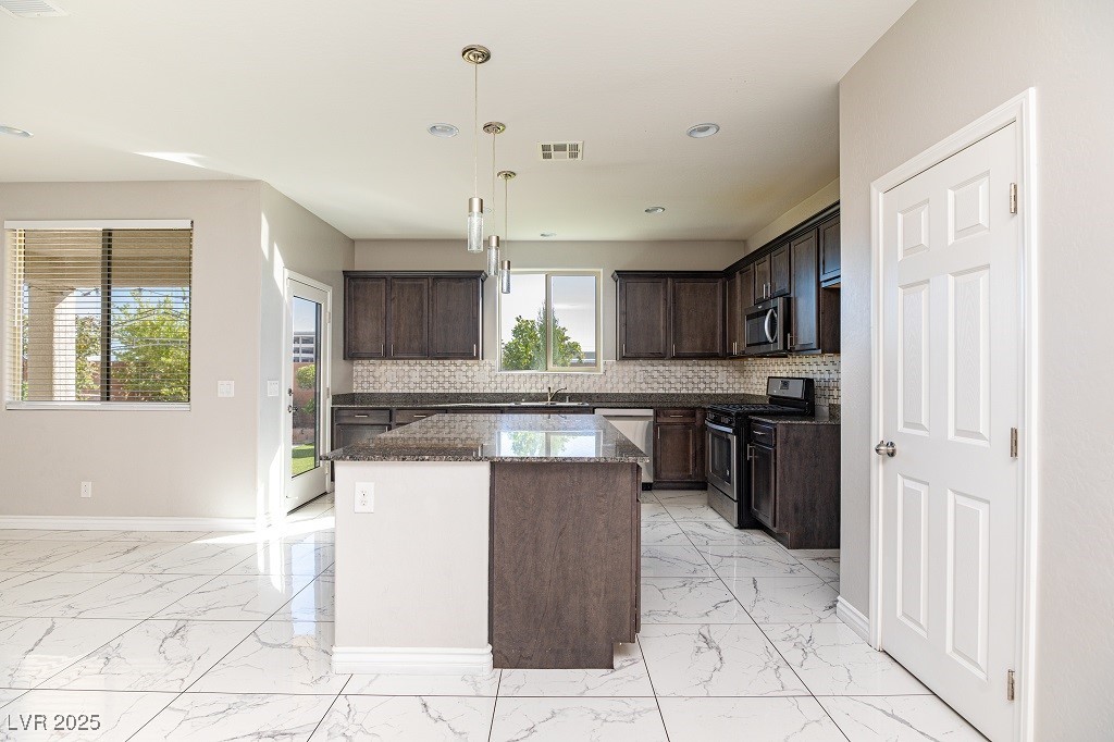 6856 Pivot Point Street Las Vegas, NV 89148 - Photo 14 of 32 Kitchen with dark stone countertops, light marble finish floors, tasteful backsplash, and recessed lighting