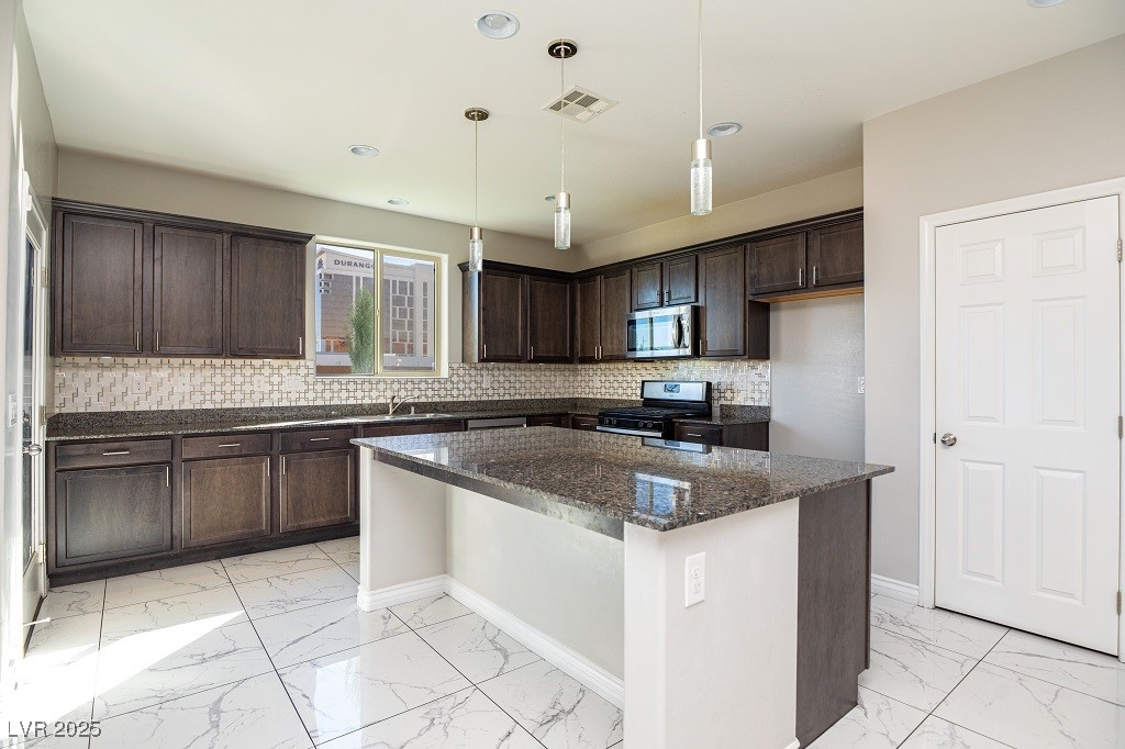 6856 Pivot Point Street Las Vegas, NV 89148 - Photo 15 of 32 Kitchen featuring dark brown cabinetry, backsplash, light marble finish flooring, dark stone countertops, and recessed lighting