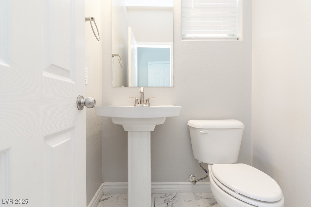 6856 Pivot Point Street Las Vegas, NV 89148 - Photo 19 of 32 Half bath with baseboards and light marble finish flooring