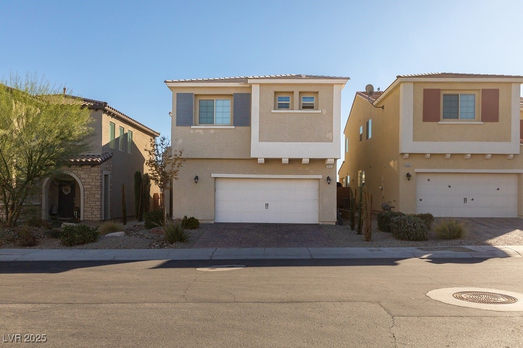 6856 Pivot Point Street Las Vegas, NV 89148 - Photo 2 of 32 Mediterranean / spanish house featuring stucco siding, decorative driveway, and a garage
