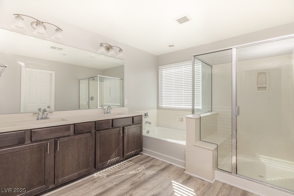6856 Pivot Point Street Las Vegas, NV 89148 - Photo 23 of 32 Bathroom with double vanity, a stall shower, light wood finished floors, and a bath