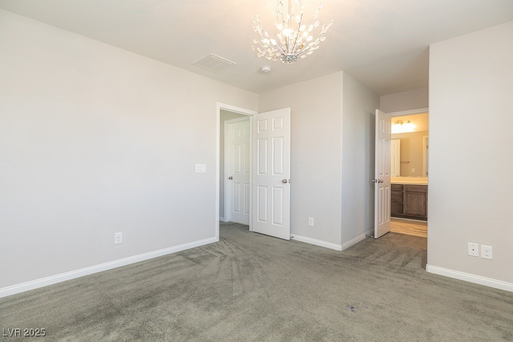 6856 Pivot Point Street Las Vegas, NV 89148 - Photo 31 of 32 Unfurnished bedroom with carpet, a chandelier, and ensuite bathroom