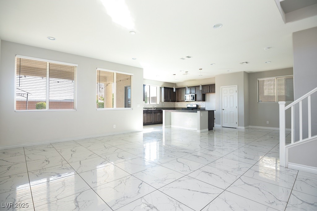 6856 Pivot Point Street Las Vegas, NV 89148 - Photo 9 of 32 Unfurnished living room with light marble finish floors, recessed lighting, and stairway