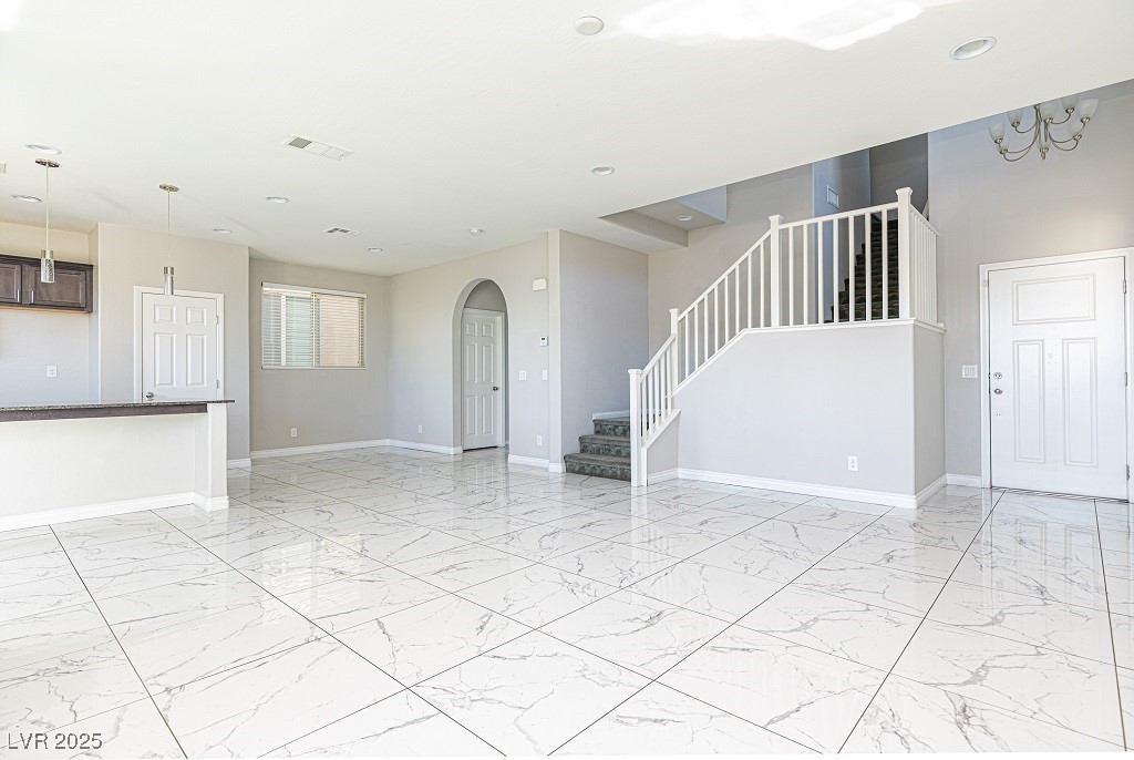 6856 Pivot Point Street Las Vegas, NV 89148 - Photo 10 of 32 Unfurnished living room with light marble finish floors, arched walkways, stairs, and recessed lighting