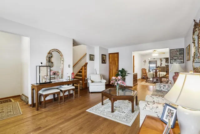 a living room with couches a coffee table and piano table with wooden floor