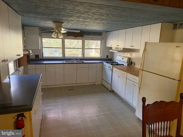 a kitchen with stainless steel appliances granite countertop a refrigerator sink and wooden cabinets