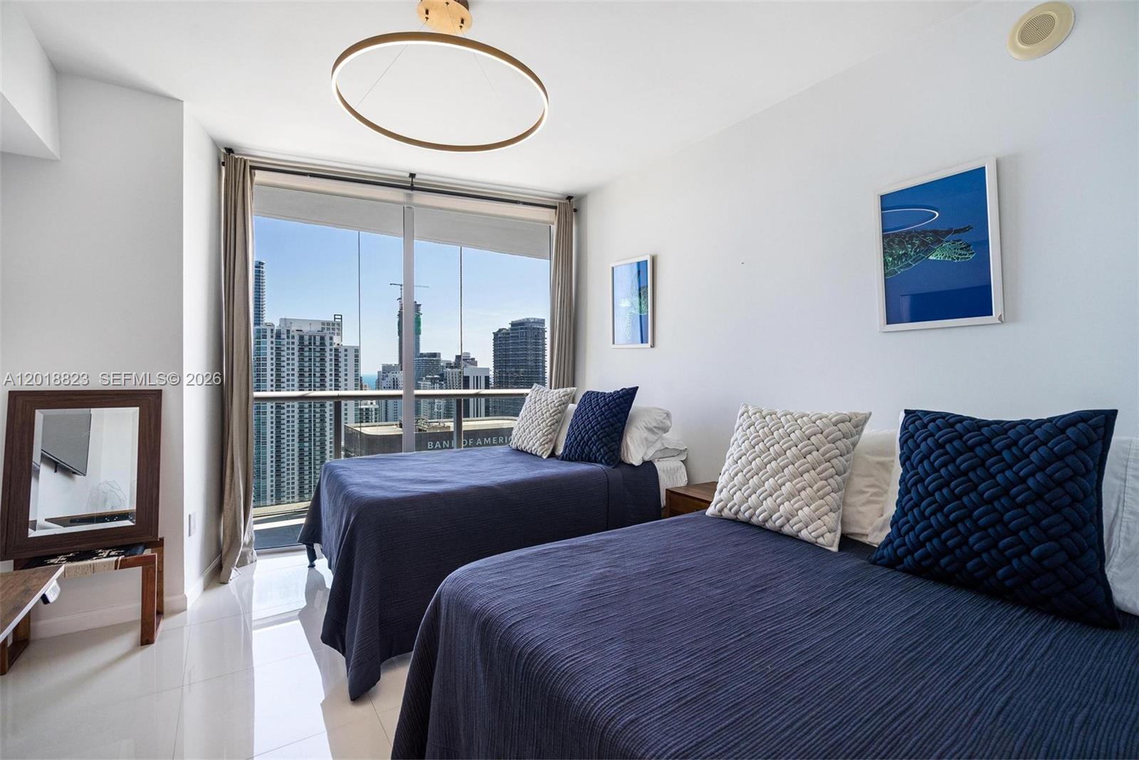 495 Brickell Avenue, Unit 4911 Miami, FL 33131 - Photo 28 of 35 a bedroom with a bed a mirror and a large window