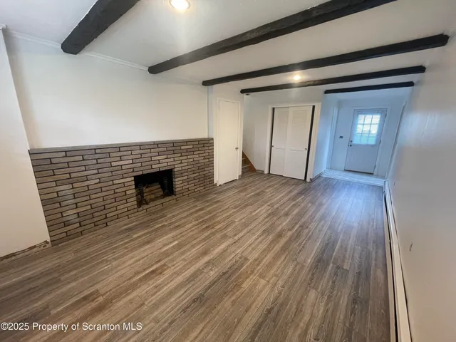 wooden floor in an empty room with a fireplace