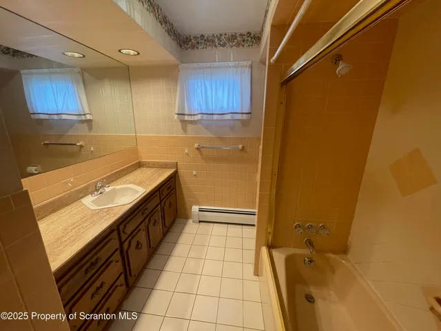 a bathroom with a granite countertop sink a toilet and bathtub
